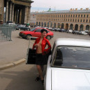 Short-haired brunette flashes in car at city center