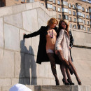 Three girls in stockings posing at city center