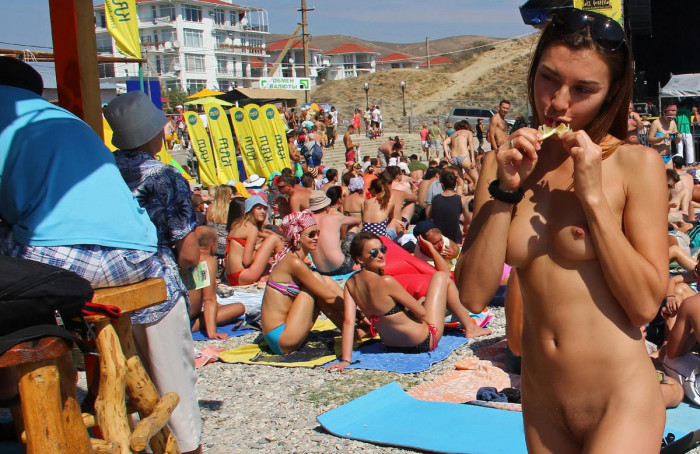 Naked nudist babe drinks some tekila at public beach bar