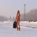 Tall slender girl with a suitcase in winter city