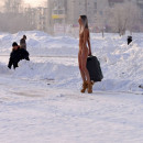 Tall slender girl with a suitcase in winter city