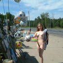 Young girl posing naked at road market