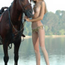 Young Alya with skinny body posing with horses outdoors