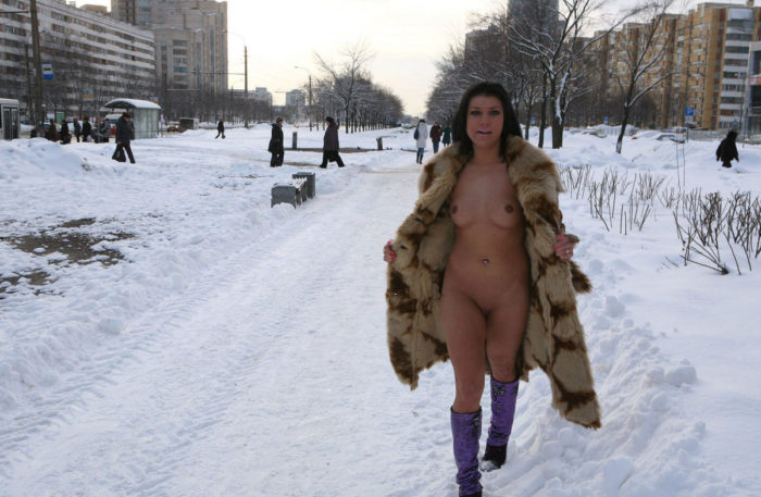 Sexy brunette with nice natural body walks at winter city