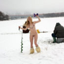 Young blonde helps fishermen at frozen river