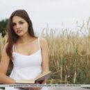 Out in the open, grassy field, Alise Moreno enjoys reading a book before deciding to get naked