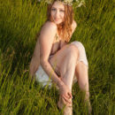 Ginger Frost delightfully poses on the grassy field baring he unshaven pussy.