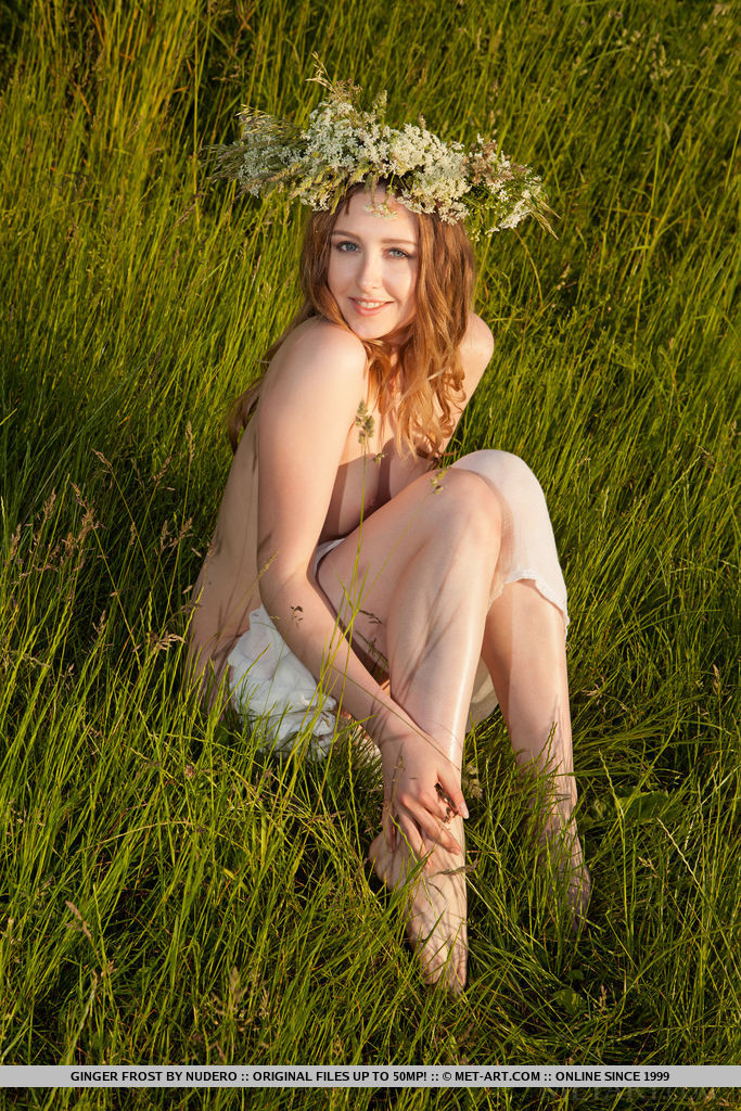 Ginger Frost delightfully poses on the grassy field baring he unshaven pussy.