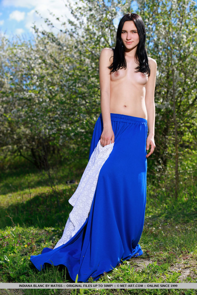 Indiana Blanc strips her long skirt and white blouse baring her slender body with   small tits and pink pussy as she poses in the outdoors.