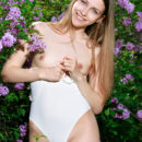 Newcomer Violet strips her one-piece bikini baring her petite body and pink   pussy as she poses in the garden.