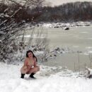 Babe with a ample round bootie on a snow-covered promenade