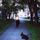 A girl without clothes walks a dog in the morning Moscow