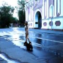 A girl without clothes walks a dog in the morning Moscow