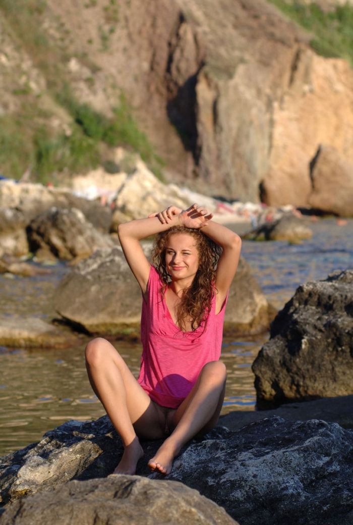 Curly-haired girl on a rocky shore