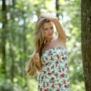 Luxurious girl undressing in a sunny forest