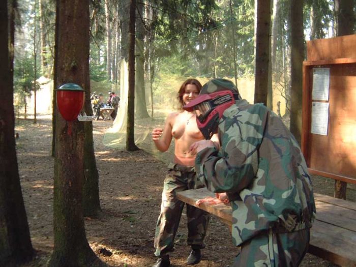 Russian girl posing with paintball gun in the forest