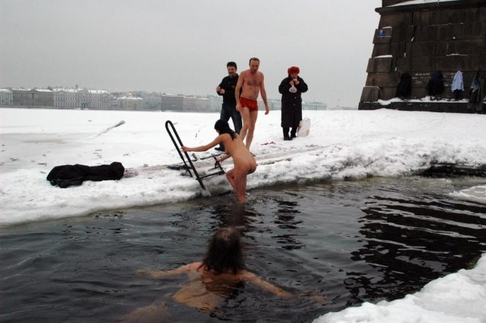 Young brunette wants to swim in an ice hole in winter