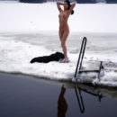 Young brunette wants to swim in an ice hole in winter