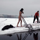 Young brunette wants to swim in an ice hole in winter