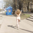 Naked girl buys some things in the kiosk