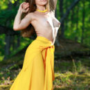 Vivian strips her long, yellow dress baring her tight body and smooth pussy in the forest.