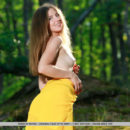 Vivian strips her long, yellow dress baring her tight body and smooth pussy in the forest.