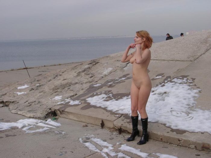 Naked girl drinks vodka with strangers on the waterfront