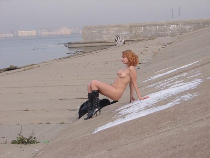 Naked girl drinks vodka with strangers on the waterfront