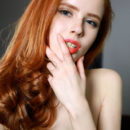 Sultry redhead Bella Milano wearing nothing but a black fishnet stockings