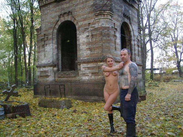 Naked blonde posing with cemetery workers