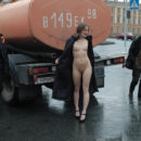 Naked young girl posing with workers
