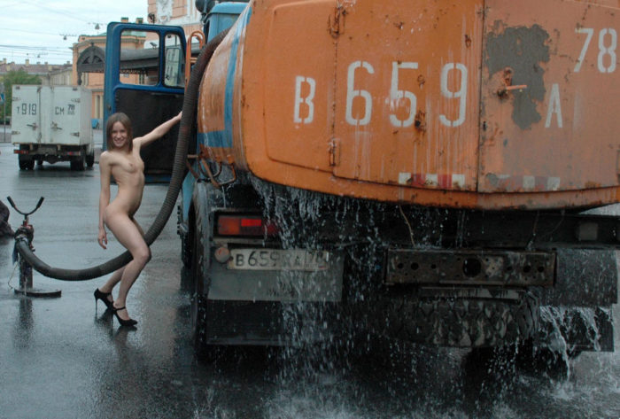 Naked young girl posing with workers