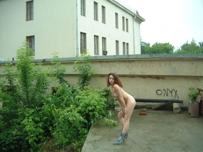 Russian girls walks in boots behind the church