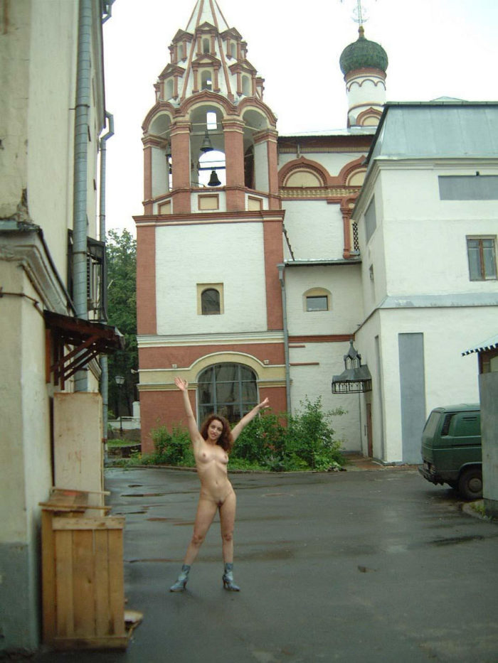 Russian girls walks in boots behind the church