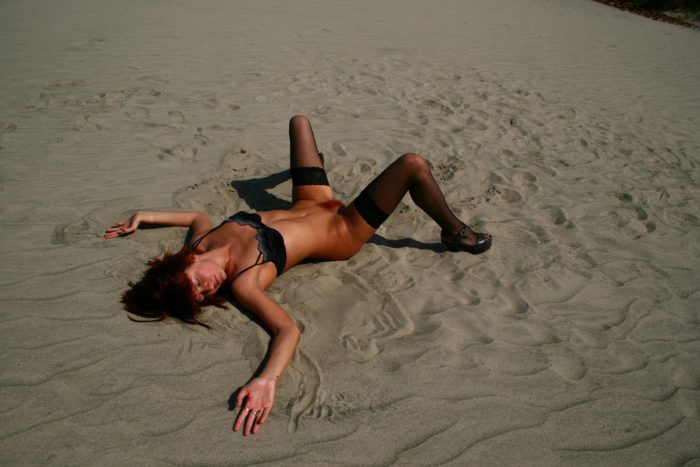 Russian redhead girl posing in stockings on the sand