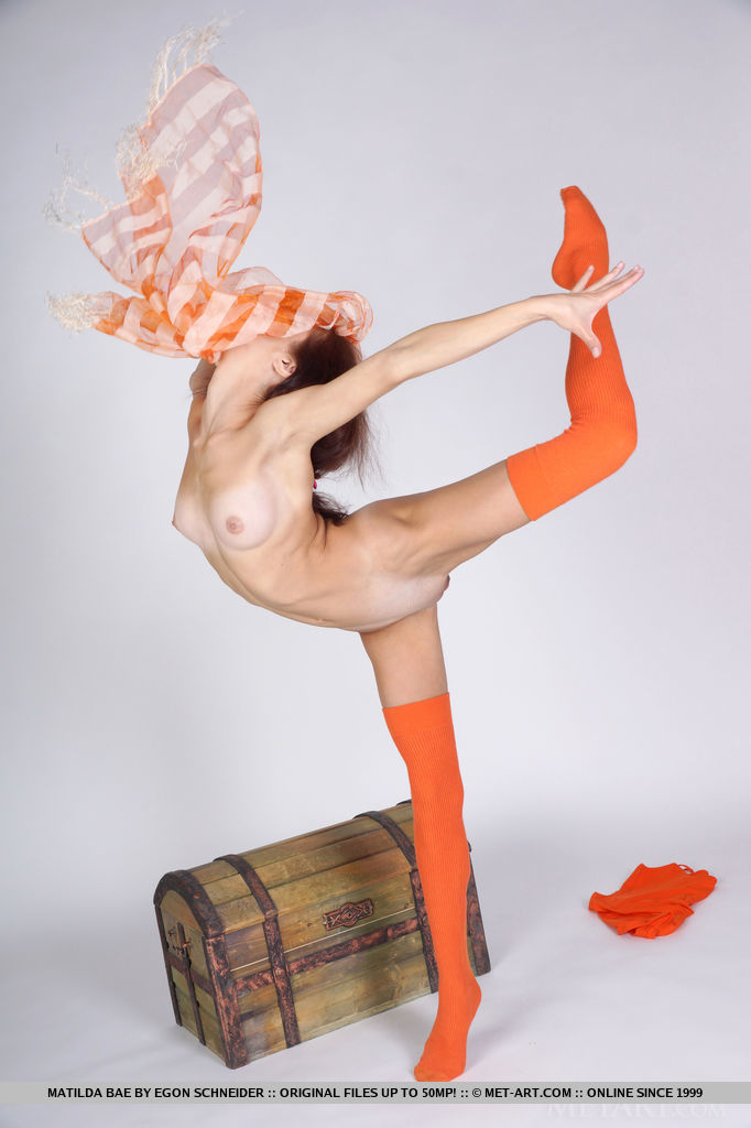 Matilda Bae showing off her flexible legs with bright orange thigh-high stocking and wide open poses