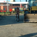 Naked blonde on bicycle at city center