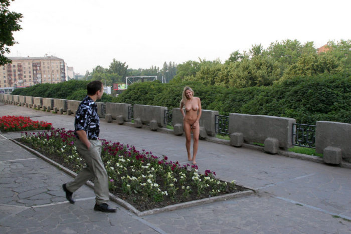 Blonde without clothes posing with a stranger at city center