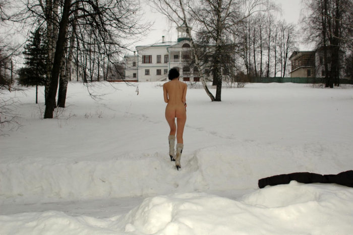 Brunette with slender body plays with a snow