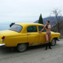 Huge-titted female next to a yellow retro car