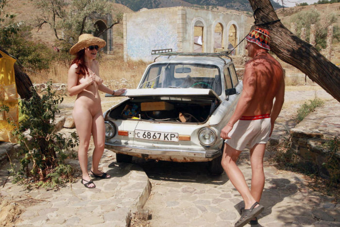 Naked redhead teen posing with a stranger and an old car