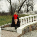 Skinny blonde Julia G in black boots and red scarf