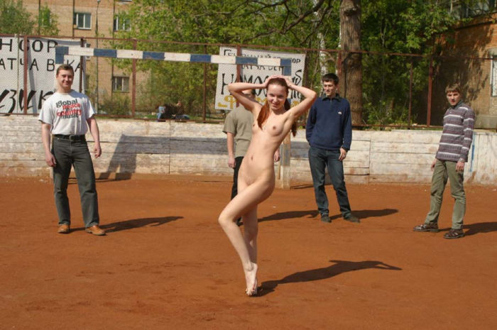 Totally nude damsel on the football ground with strangers