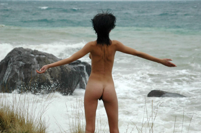 Girl posing next to the stormy sea