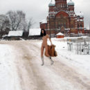 Lovely teen undresses in front of an old church