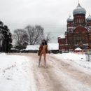 Lovely teen undresses in front of an old church