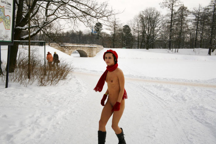 Naked girl in a red beret in a winter park