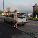 Nude blonde posing at city center
