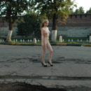 Nude blonde posing at city center
