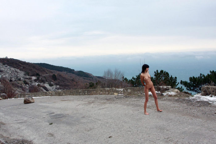 Skinny brunette at blockage in the mountain road